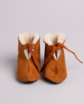 Load image into Gallery viewer, Pair of brown baby boots with white fur lining on a light gray background
