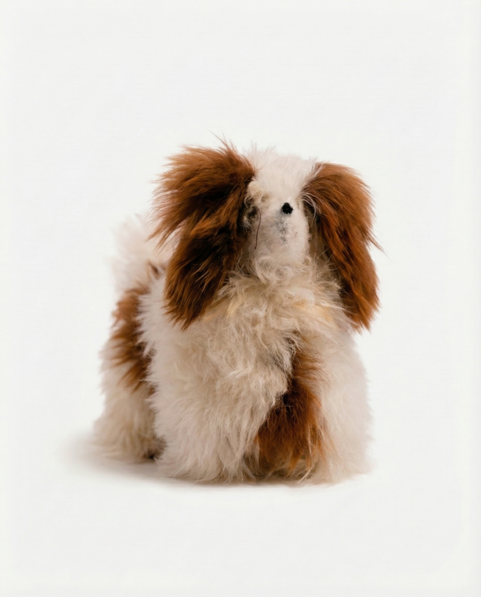 Stuffed toy dog with brown and white fur on a white background